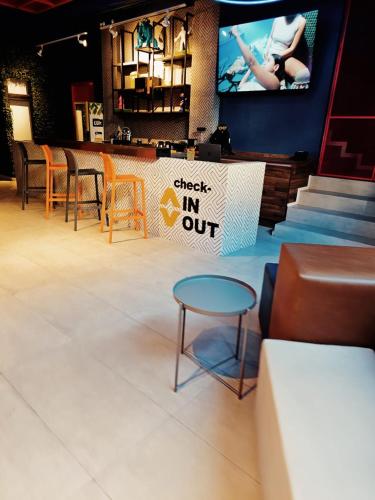 a table and chairs and a sign that reads check in out at ALT URBANA in León