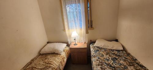 - 2 lits dans une petite chambre avec fenêtre dans l'établissement Casa rustica en Mar Chiquita, à Balneario Mar Chiquita