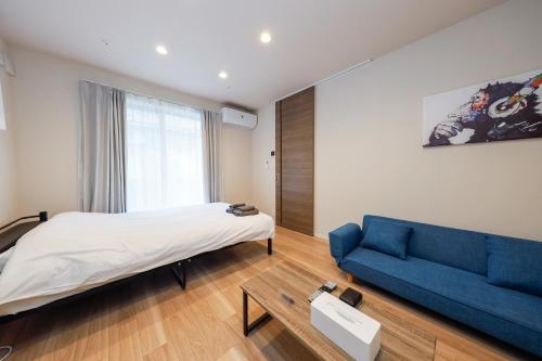 um quarto com uma cama e um sofá azul em La Terrasse Higashikomagata - Vacation STAY 17380v em Tóquio