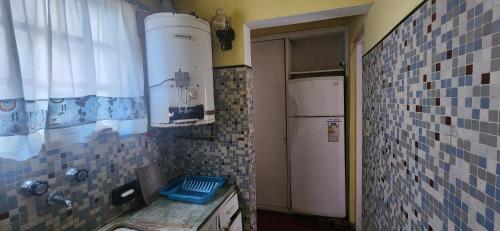 a small kitchen with blue tiles on the wall at Casa rustica en Mar Chiquita in Balneario Mar Chiquita