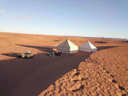 two tents in the middle of a desert at Erg Chigaga Wil Camp in El Gouera