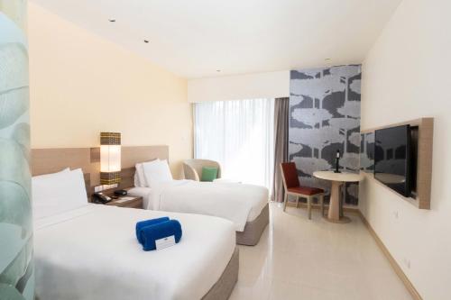 a hotel room with two beds and a tv at Holiday Inn Express Phuket Patong Beach Central by IHG in Patong Beach