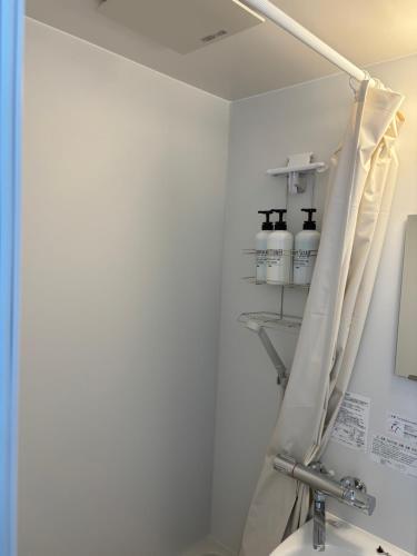 baño con aseo y estante con botellas en Guesthouse Fujinokura Kawaguchiko Ekimaeten, en Fujikawaguchiko