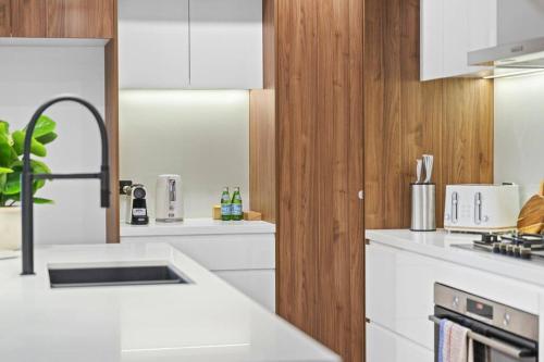 a kitchen with white counter tops and wooden walls at Luxury Retreat & Spacious 4BR House in Willoughby in Sydney