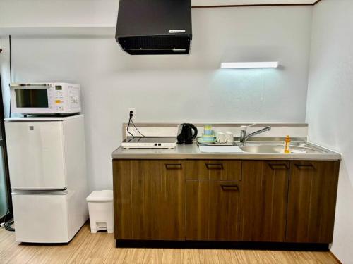 京都市にある壬生の宿 Mibu no yado 無料駐車場付 自転車4台無料貸出のシンク、電子レンジ、冷蔵庫を備えたキッチン