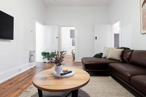 a living room with a couch and a coffee table at Charming Cottage Near The City With Parking in Launceston