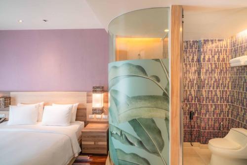 a hotel room with a bed and a shower at Holiday Inn Express Phuket Patong Beach Central by IHG in Patong Beach