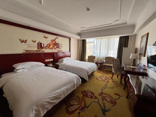 a hotel room with two beds and a desk at Foshan Shiwan Hotel in Foshan