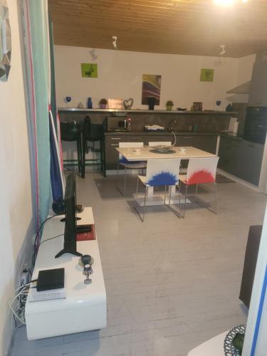 Cette chambre comprend un bureau avec un ordinateur et des chaises. dans l'établissement Superbe appartement avec parking, à Roanne