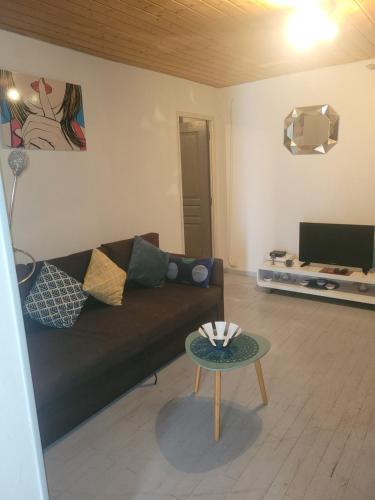 uma sala de estar com um sofá e uma mesa em Superbe appartement avec parking em Roanne