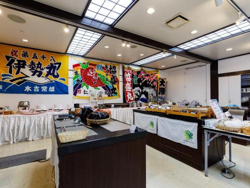 Tabist Hotel Nemuro Kaiyoutei في نيمورو: مطعم وجبات سريعة مع طاولات وعلامات على الحائط
