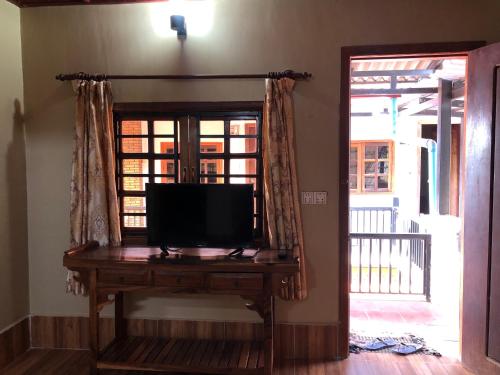 a television sitting on a table next to a window at Blue Moon Guesthouse and Bar in Kampot