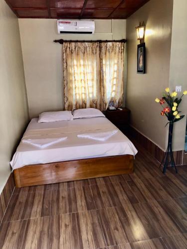a bedroom with a bed and a vase of flowers at Blue Moon Guesthouse and Bar in Kampot