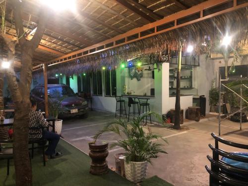 Blue Moon Guesthouse and Bar في كامبوت: امرأة تجلس في كرسي في مرآب للسيارات في الليل