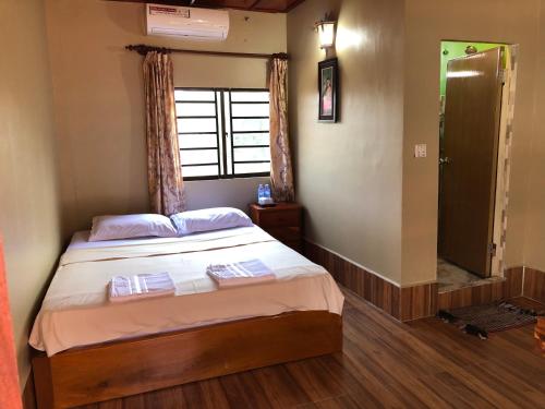 a small bedroom with a bed and a window at Blue Moon Guesthouse and Bar in Kampot