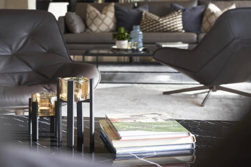 a living room with a table with books and a couch at AC Hotel by Marriott Kuantan in Kuantan
