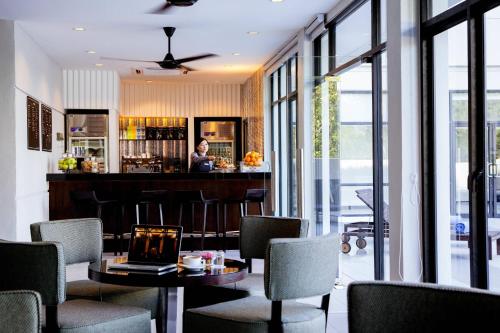 a bar in a restaurant with a table and chairs at AC Hotel by Marriott Kuantan in Kuantan
