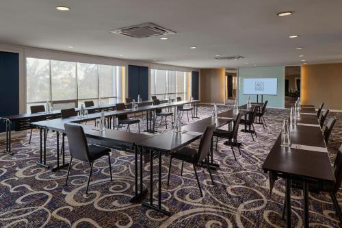 a conference room with tables and chairs and a screen at AC Hotel by Marriott Kuantan in Kuantan