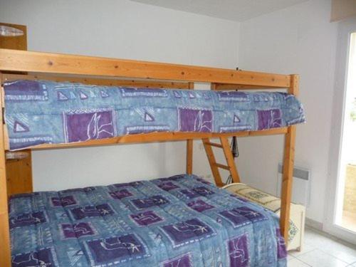 - une chambre avec des lits superposés et une couverture bleue et violette dans l'établissement Villa au Barcarès: Piscine, Parking, 2 Chambres, Terrasse Plein Sud, Proche Lac et Commodités - FR-1-782-22, au Barcarès