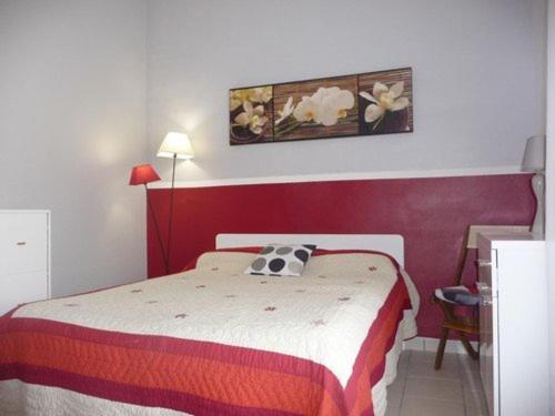 - une chambre avec un lit doté d'une tête de lit rouge dans l'établissement Appartement T2 avec Terrasse, Parking, Proche Plage et Commerces - Le Barcarès - FR-1-782-40, au Barcarès