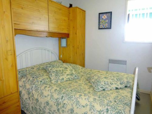 une chambre avec un lit avec une tête de lit en bois dans l'établissement Appartement climatisé proche plage avec parking au Barcarès - FR-1-782-20, au Barcarès