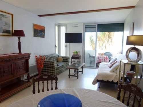 un salon avec un canapé et une table dans l'établissement Grand T2 proche plage et commerces, parking privé - FR-1-782-36, au Barcarès