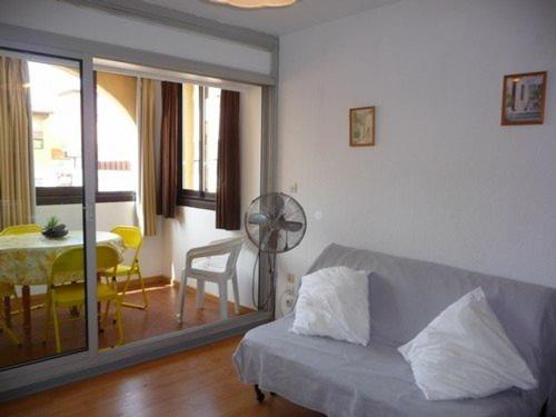 - un salon avec un canapé et une table à manger dans l'établissement Studio Cabine avec Terrasse, Accès Direct Plage, Plein Centre Le Barcarès, Équipé pour 4 Pers - FR-1-782-15, au Barcarès