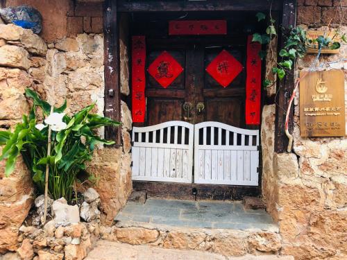 麗江的住宿－Lijiang Jayden Lodge臣安山居民宿 - Namaste，石头建筑的入口,带有木门