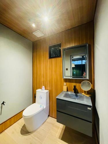 a bathroom with a white toilet and a sink at Jinjer Resort in Cavinti