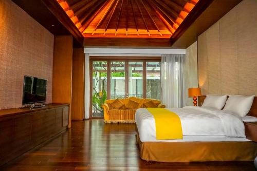 1 dormitorio con 1 cama, TV y sofá en Louis Kienne Bandungan, en Srondolwetan