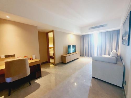 a living room with a couch and a television at JD POLMAN Hotel in Phnom Penh