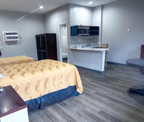 a room with a bed and a kitchen and a sink at El Cajon Inn & Suites in El Cajon