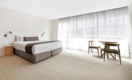 1 dormitorio con cama, mesa y escritorio en Abode Phillip, en Canberra