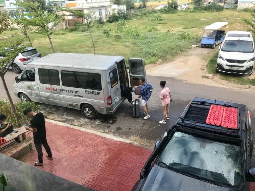 a group of people loading luggage into a white van at Khách Sạn Nhơn Lý LYS HOTEL in Quy Nhon