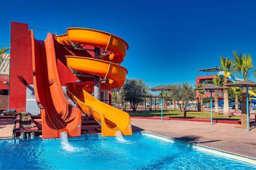 a water slide in a park with a swimming pool at Eden Andalou Aquapark & Spa in Marrakech