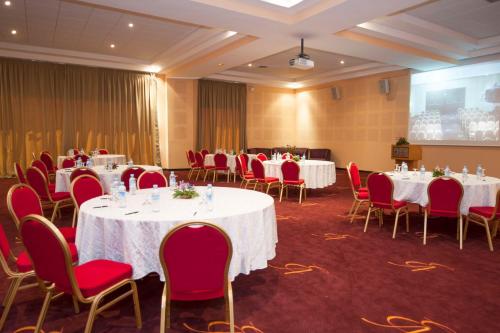 a conference room with white tables and red chairs at Eden Andalou Aquapark & Spa in Marrakech