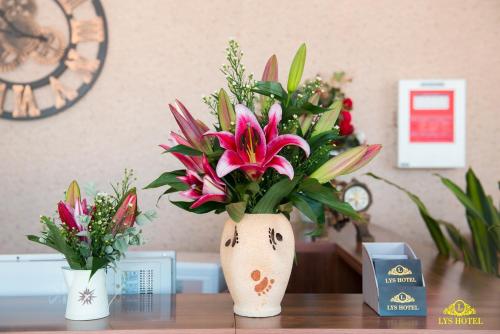 a vase filled with flowers sitting on a table at Khách Sạn Nhơn Lý LYS HOTEL in Quy Nhon