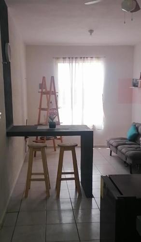 a table in a living room with two stools at La casa gris in Tulum