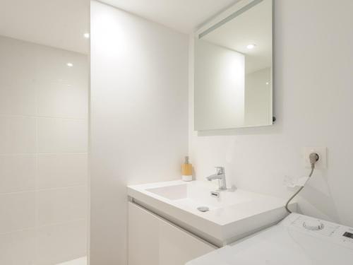 une salle de bain blanche avec un lavabo et un miroir dans l'établissement Charmant Studio Mezzanine rénové au Centre de La Rochelle, Proche Vieux Port et Plages - FR-1-535-54, à La Rochelle