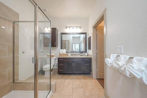 y baño con ducha, aseo y lavamanos. en Elite Retro Urban Luxe en Houston