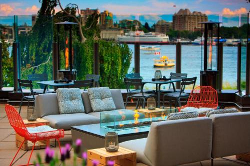 a patio with couches and tables and a view of the water at Delta Hotels by Marriott Victoria Ocean Pointe Resort in Victoria