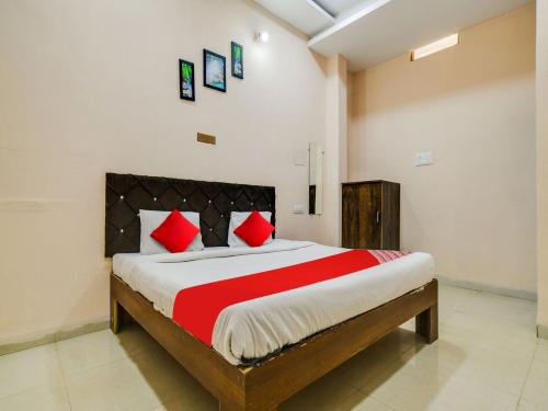 a bedroom with a large bed with red pillows at OYO Hotel Airport View in Indore