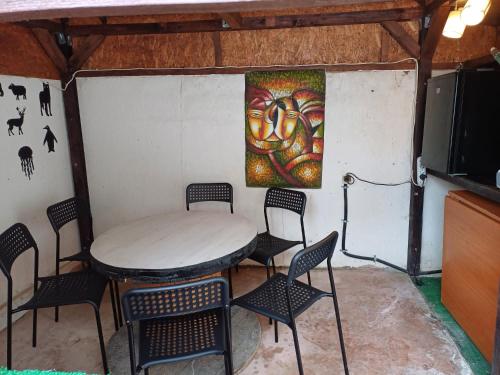 a room with a table and chairs and a painting on the wall at Casa KariAna in Năvodari