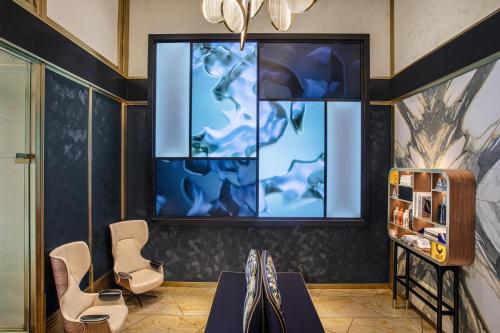 a room with two chairs and a large window at Le Meridien New York, Central Park in New York