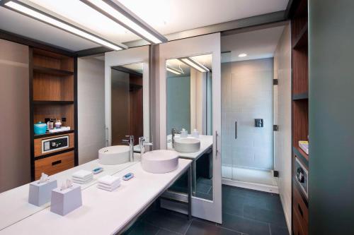 雪城的住宿－雅樂軒錫拉丘茲內港酒店，一间带两个盥洗盆和淋浴的浴室