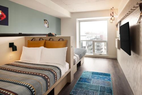 a bedroom with two beds and a large window at Moxy Halifax Downtown in Halifax