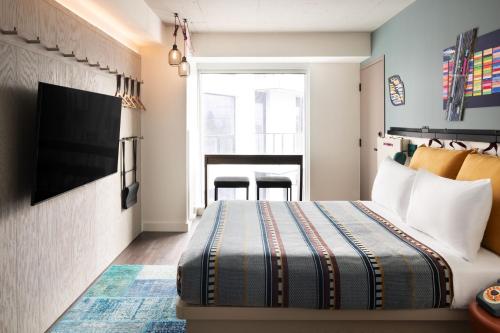 a hotel room with a bed and a table at Moxy Halifax Downtown in Halifax