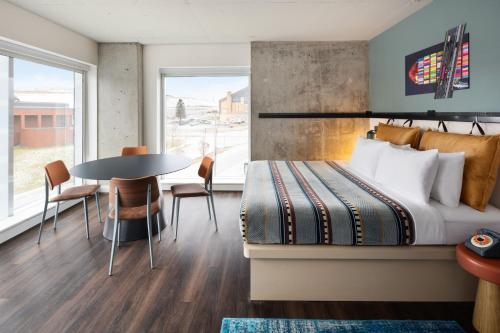 a hotel room with a bed and a table and chairs at Moxy Halifax Downtown in Halifax