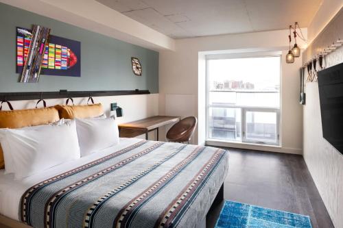 a hotel room with a bed and a window at Moxy Halifax Downtown in Halifax