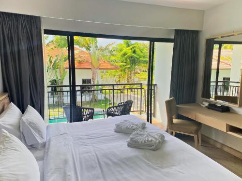 a bedroom with a bed with two towels on it at D Varee Mai Khao Beach Resort, Thailand in Mai Khao Beach